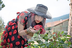 Woman smelling red roses in garden