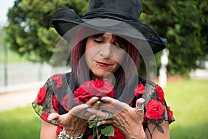 Woman smelling red roses in garden