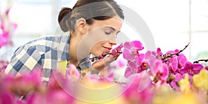 Woman smells the flowers in garden, fragrance of orchids