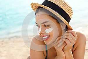 Woman smile applying sun cream on face. Skincare. Body Sun protection