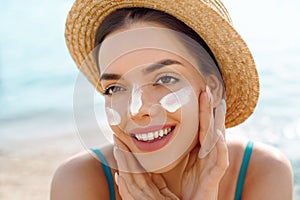Woman smile applying sun cream on face. Skincare. Body Sun protection. sunscreen.
