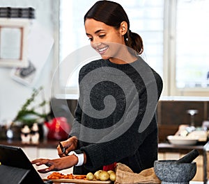 Woman, smile and cooking in kitchen with tablet for online recipe, explanation video and research at home. Female person