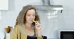 woman smile, eating green apple fruit, looking at space in kitchen with copy space. beautiful caucasian pregnant woman cooking