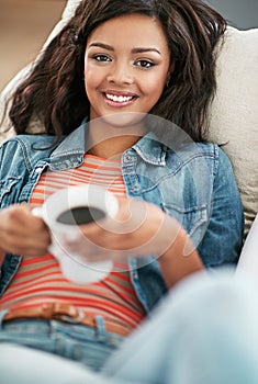Woman, smile and portrait with coffee on sofa in home for relax on weekend with happiness. Female person, happy and