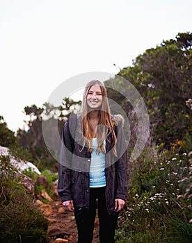 Woman, smile and portrait for hiking and adventure in nature with trail for walking outdoor for exercise. Young person