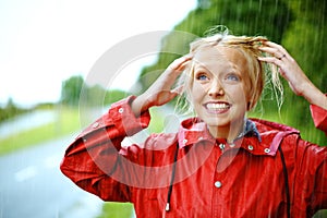 Woman, smile and raincoat or hands in storm, wet and cold from weather, winter and nature. Happy female person, fashion