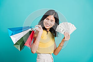 Woman smile standing wear, She holding shopping bags and dollars money fan