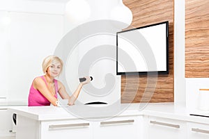 Woman smile watching tv hold remote control