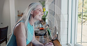 Woman, smile and window in kitchen thinking of life, mindfulness and retirement for old age. Mature people, memory and