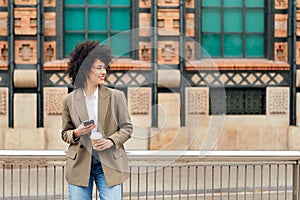 woman smiles happy with a mobile phone in the hand