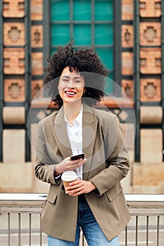 woman smiles happy with a mobile phone in the hand