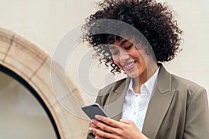 woman smiles happy typing message with her phone
