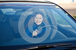 Woman smiling through the car windshield