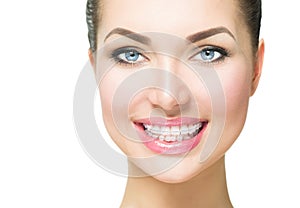 Woman smiling with ceramic braces on teeth