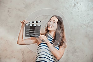 Woman smiling with clapper board movie audition concept