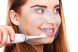 Woman smiling cleaning teeth with braces