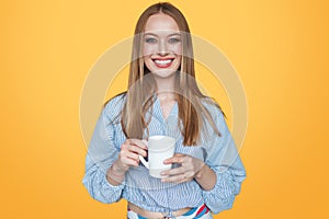 Woman smiling with cup in studio