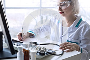 Woman smiling doctor working on the computer