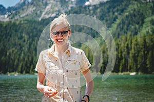 Woman smiling in front of the Teton mountain range across String Lake in Grand Teton National Park