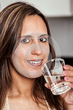 Woman smiling with a glass of water