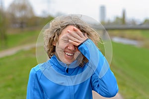 Woman smiling with her hand to her forehead