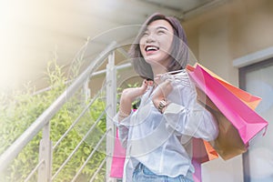 Woman smiling and hold shopping bug , she happy time on the day mid year sale