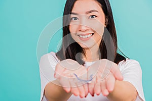 woman smiling holding silicone orthodontic retainers for teeth on hand palm