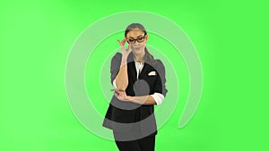 Woman smiling while looking at camera. Green screen