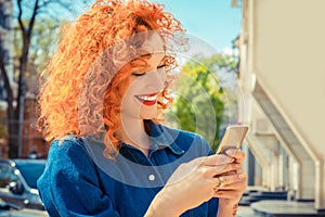 Woman, smiling, looking her mobile phone texting, reading sms message