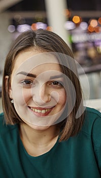 Woman smiling with perfect smile in mall and looking at camera. Image for your stories.