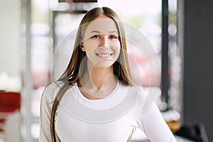 Woman smiling with perfect smile and white teeth in a mall looking at camera