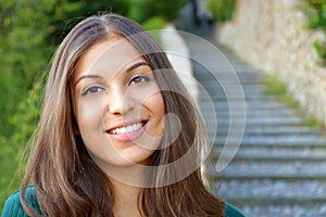 Woman smiling with perfect smile and white teeth outdoor and looking at camera. Copyspace.