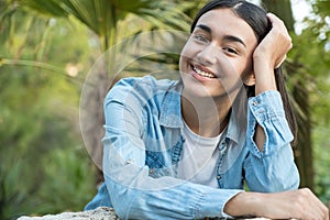 Woman smiling with a perfect smile and white teeth in a park and looking at the camera