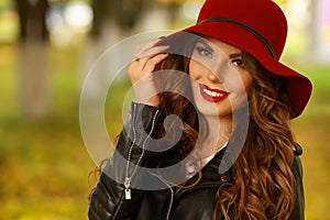 Woman smiling with perfect smile and white teeth in a park and looking at camera.