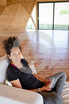 Woman smiling while relaxing reading with an ebook.