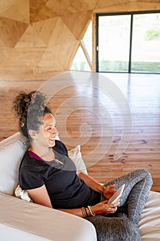 Woman smiling while relaxing reading with an ebook.