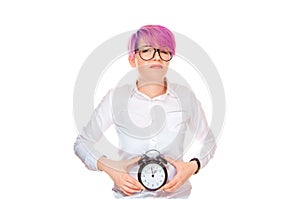 Woman smiling sadly holding a clock at belly showing that her biological watch is ticking