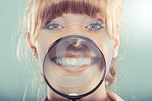 Woman smiling showing teeth with magnifying glass