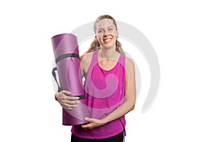 Woman smiling in sports attire holding yoga mat with copyspace