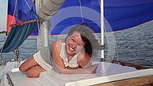 Woman smiling unnaturally at camera, yachting, cruise, vacation