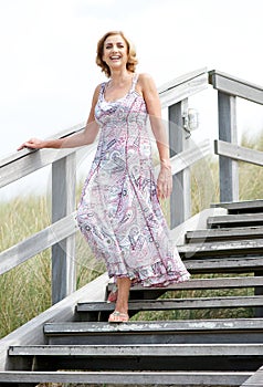 Woman smiling and walking downstairs outdoors