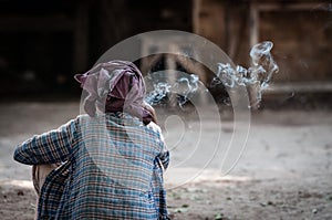 A woman smokes cheroot while resting