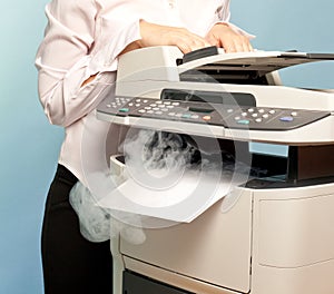 Woman with smoking copier at office