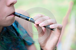 Woman smoking electronic cigarette outdoor