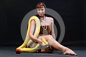 Woman with a snake eating red apple