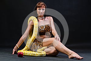 Woman with a snake holding red apple