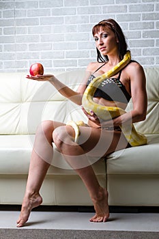 Woman with a snake holding red apple