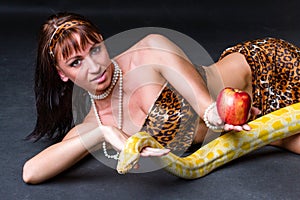 Woman with a snake holding red apple