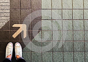 Woman sneaker shoe and Arrow on street with copy space