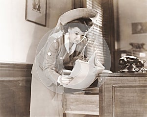 Woman sneaking a look at documents in office